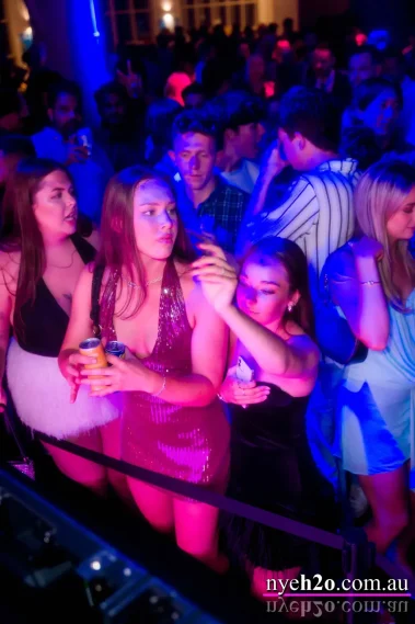 Women enjoying the music at the front of a busy dance floor at a Melbourne New Year's Eve event