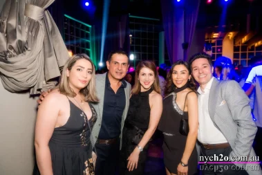 Guests dressed in elegant attire enjoying the H2O Melbourne New Year's Eve celebration at Metropolis Southbank, surrounded by colorful lights and festive energy