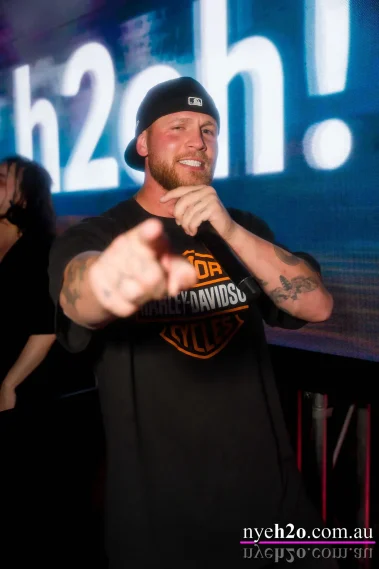 MC hosting a live Melbourne New Year’s Eve event on stage, engaging the crowd while dancing on stage