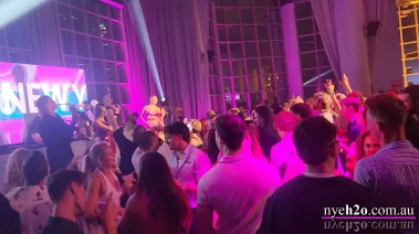 Huge crowd of clubbers celebrating with hands in the air on a packed dance floor at midnight
