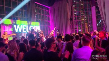 Huge crowd of clubbers celebrating with hands in the air on a packed dance floor at